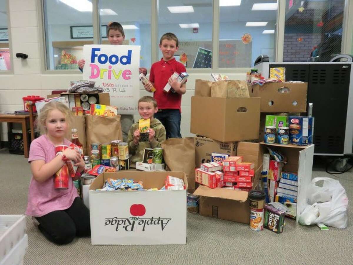 MAKING A DIFFERENCE: Lake Ann students stand by the food collected over the past week at the Elementary School. The students are, from left to right, Alex Beardslee, Dakota Johnson, Robert Brown and Bradley Shelton. (Courtesy Photo)