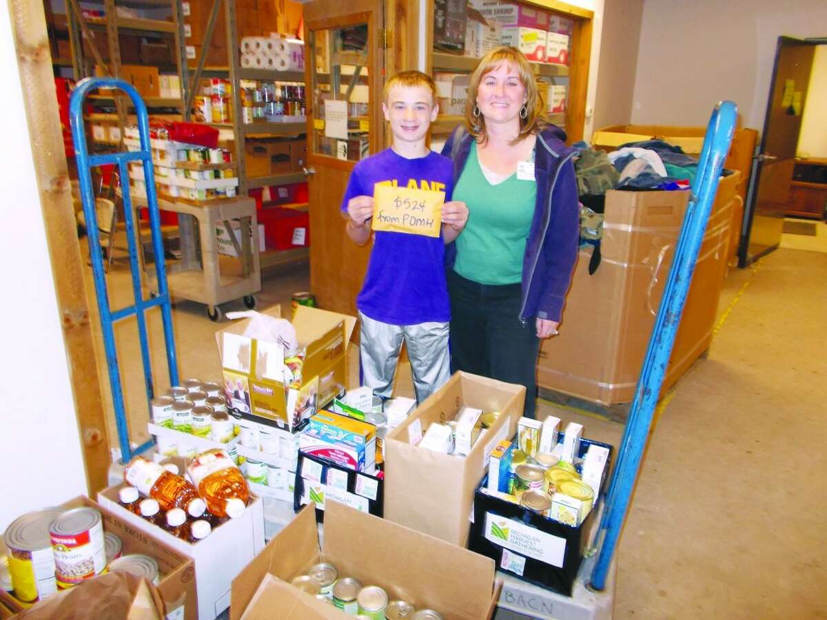 FOOD DRIVE: Trevor Crawford helps his mother, Julie Bankston, tally the gifts to Paul Oliver Memorial Hospital’s food drive, which totaled 599 lbs of food and over $1000 dollars in cash donations. (Courtesy photo)