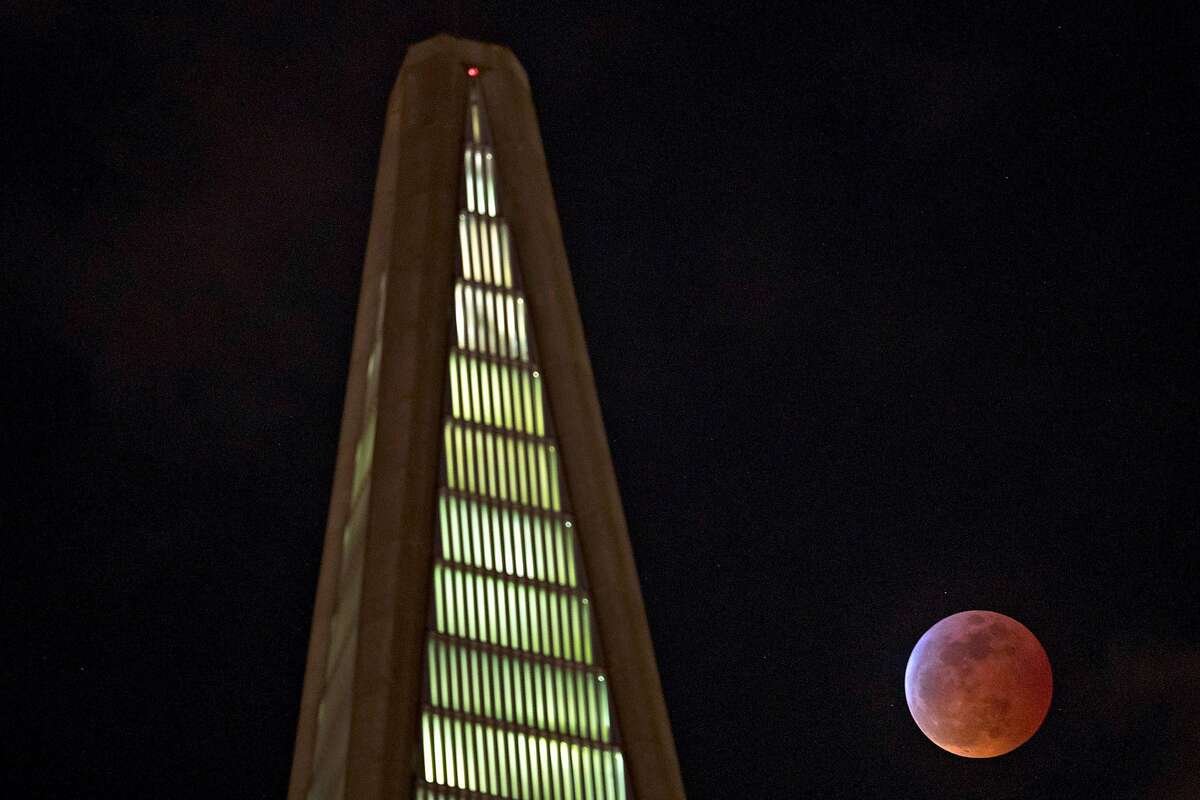 The fully-eclipsed Super Blood Wolf Moon is visible alongside the Transamerica Pyramid in San Francisco, Calif., on Sunday, January 20, 2019.