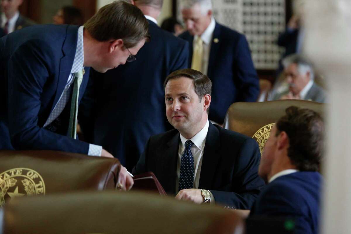 Rep. Will Metcalf, R-Conroe, talks with Rep. Dustin Burrows, R-Lubbock, in the Texas House of Representatives chamber Thursday, April 11, 2019 in Austin, Texas. Burrows, whose involvement in a controversial secret meeting has raised questions about his leadership, resigned Friday from his post as chair of the House GOP Caucus. (James Gregg/Austin American-Statesman via AP)