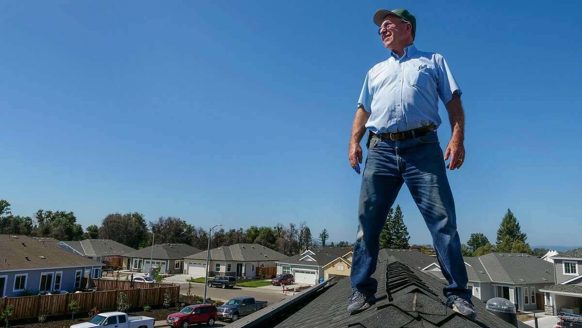 Bob Cipolla stands on the roof with the solar panels at his new home which is under construction, Friday August 16, 2019, in Santa Rosa, Ca. HIs home is all-electric with the help of Sonoma Clean Power's Advanced Energy Republic program that helps homeowners affected by October 2017 fires republic energy efficient homes. The electricity that is generated from his home will feed the grind to help his neighbors with their power. � I use to think off the grid was in the woods but it�s right here,� said Cipolla.