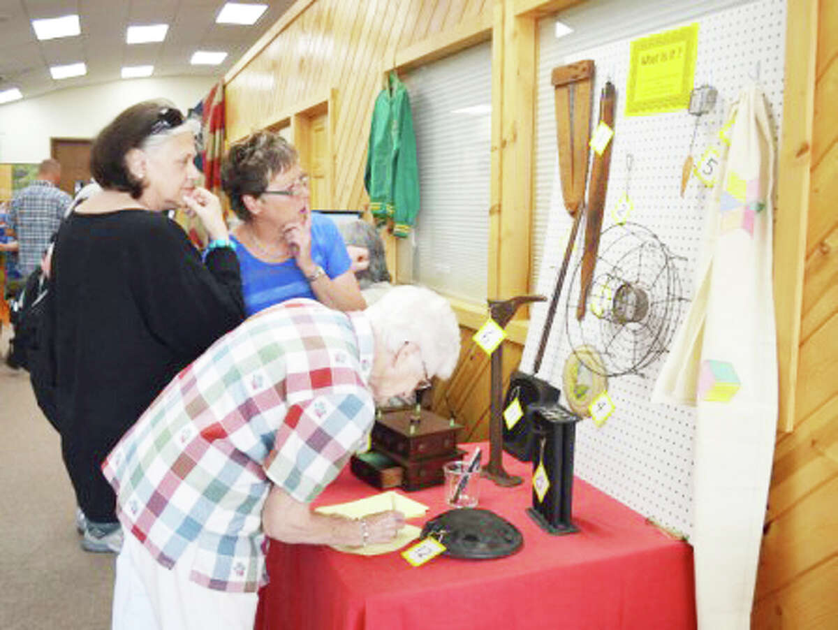 GUESSING GAME: Visitors (from left to right) Beth Ann Blass-Murphy, Susan McConnell and Alice Truxton try their luck at the “What is it?” game during the annual Lake County History Day.