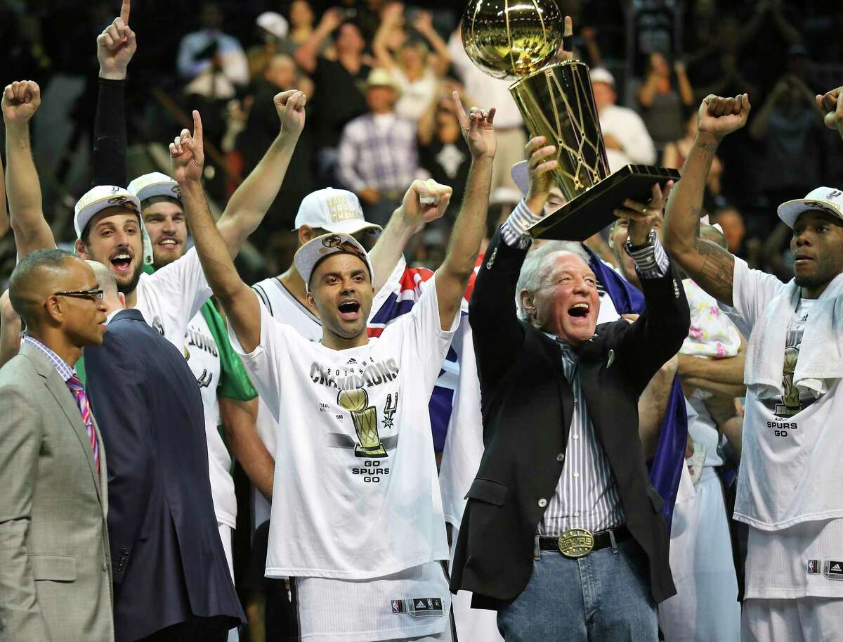 The Spurs’ Marco Belinelli, Tony Parker, owner Peter Holt, Kawhi Leonard and others celebrate after defeating the Miami Heat in Game 5 to win the 2014 NBA Finals on June 15, 2014 at the AT&T Center. The Spurs won 104-87.