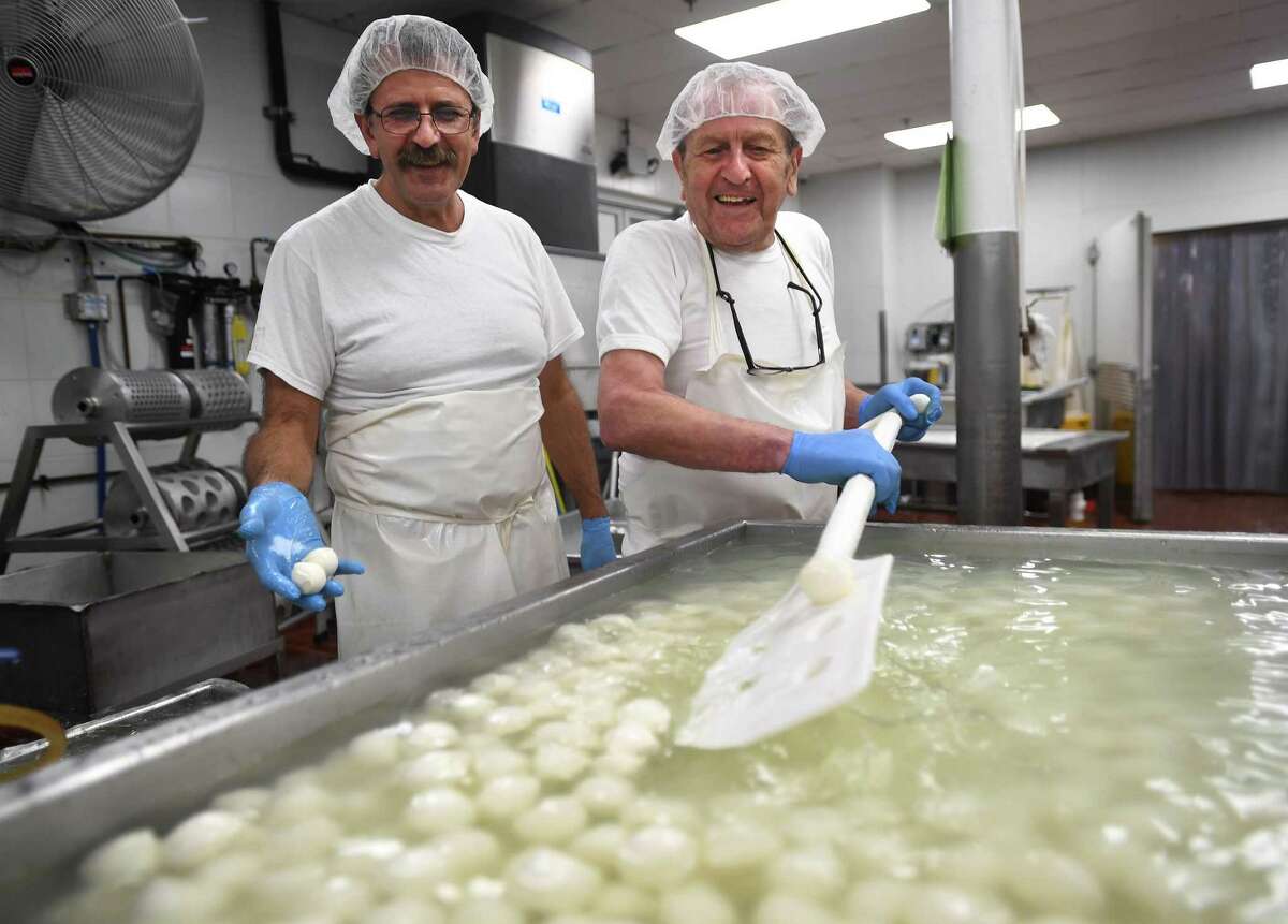 Brothers and founders of Liuzzi Cheese Nicola, left, and Lino Liuzzi with bocconcini, or “bite-sized” mozzarella at Liuzzi Cheese in Hamden.
