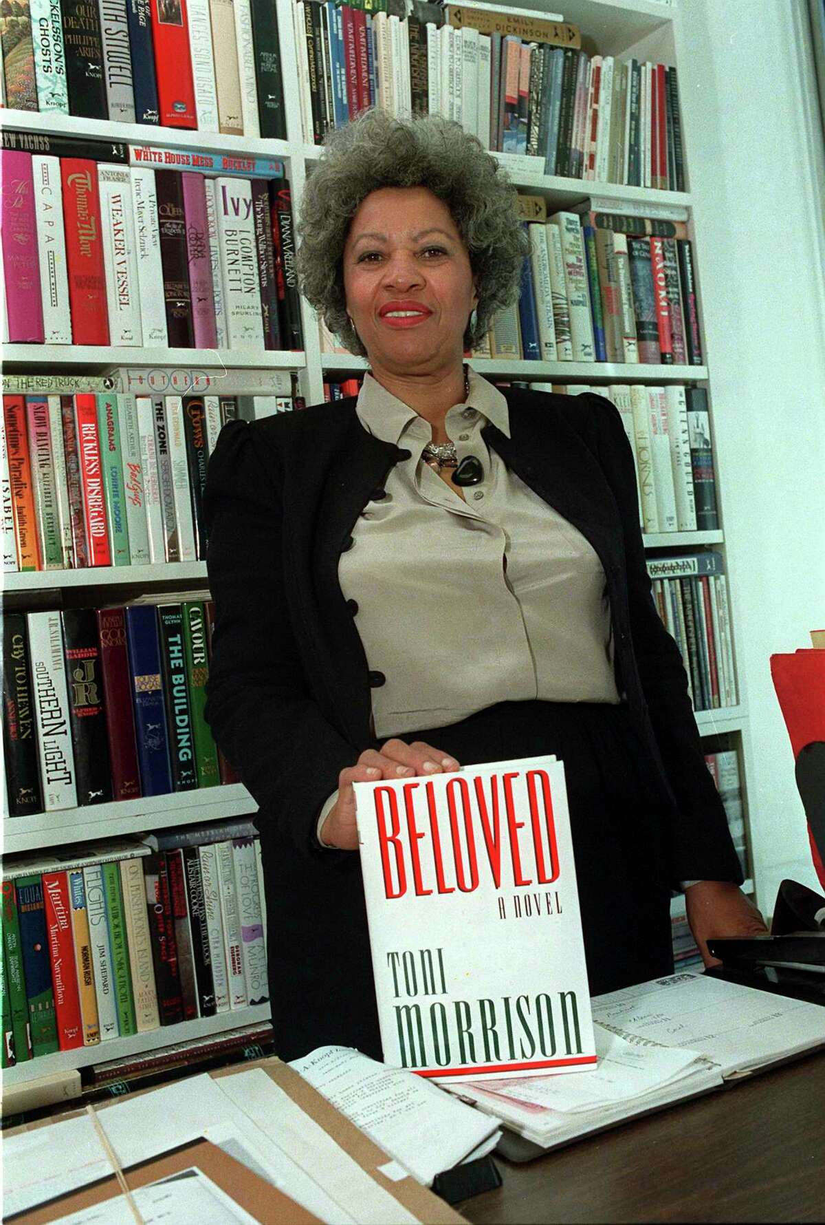 In this September 1987 file photo, author Toni Morrison poses with a copy of her book "Beloved" in New York.
