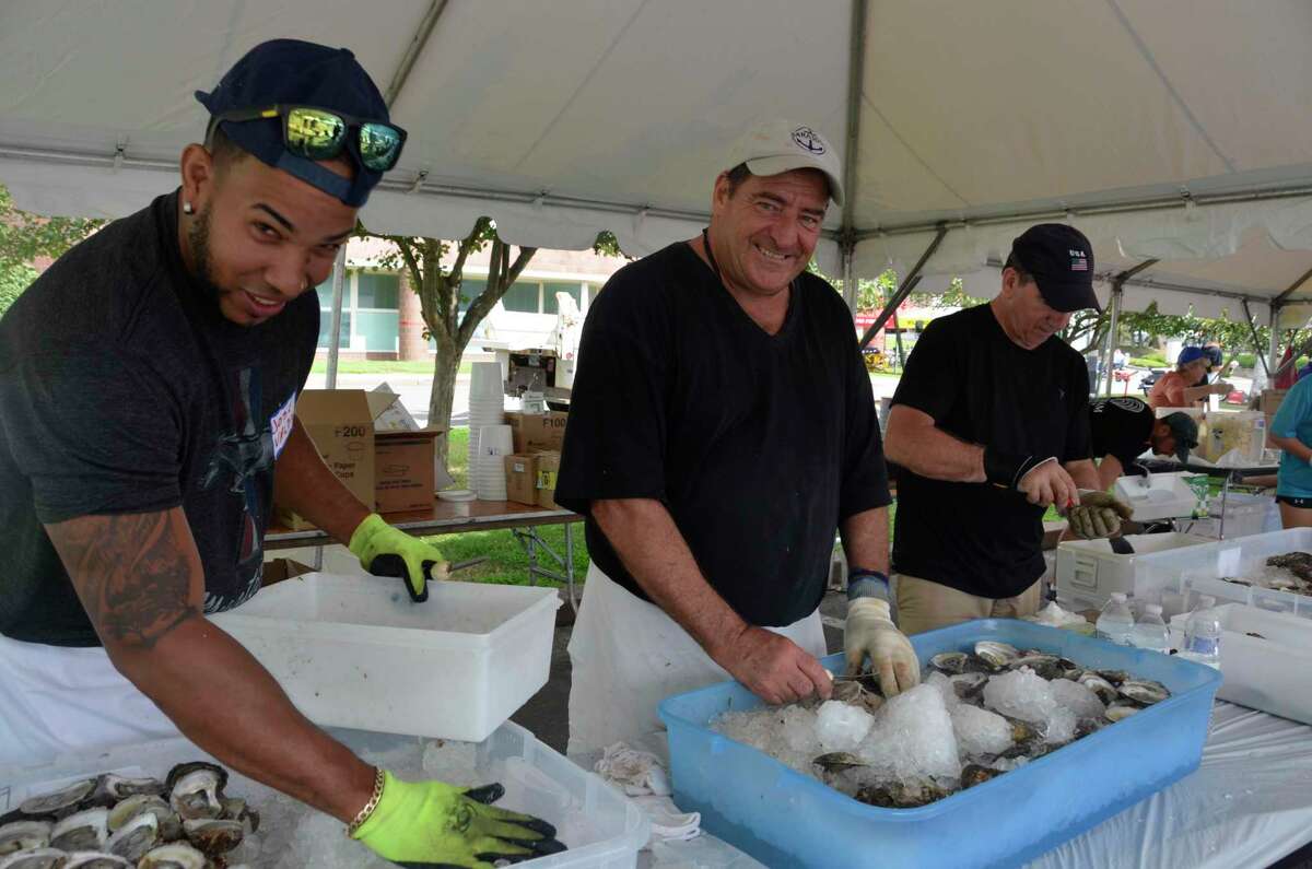 Volunteers, from left to right, Jose Valdez, Peter DeRosa and Chip Giorgi, shuck oysters at the Annual Milford Oyster Festival Saturday, Aug. 17, 2019. After a one-year hiatus due to COVID-19, the festival is set to return this summer.