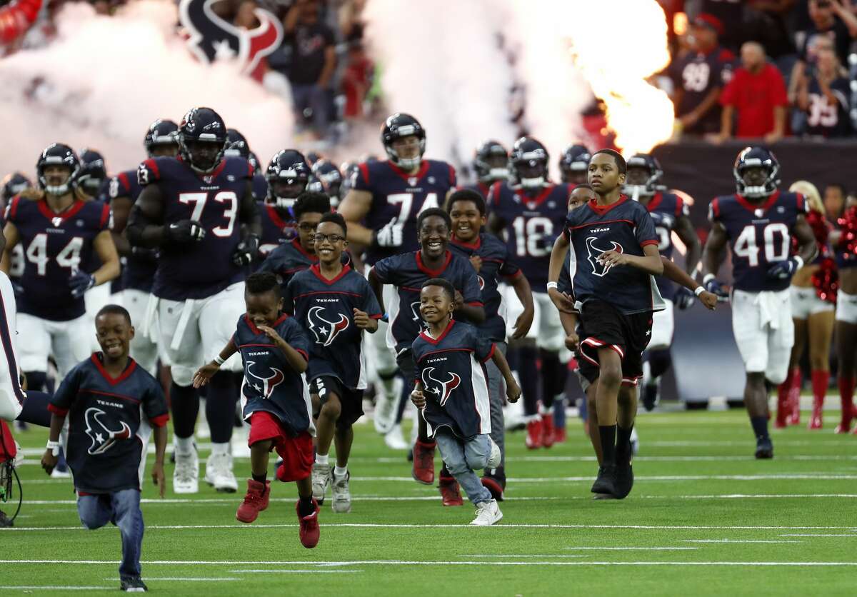 The Houston Texans are led onto the field by a group of youngsters before an NFL preseason football game against the Detroit Lions at NRG Stadium on Saturday, Aug. 17, 2019, in Houston.