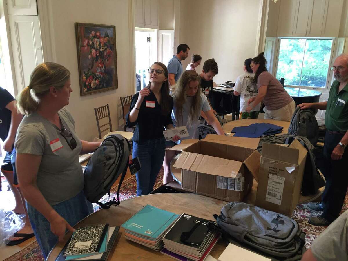 Volunteers hand out backpacks and school supplies from Neighbor to Neighbor last week at the Tomes-Higgins House in Greenwich.