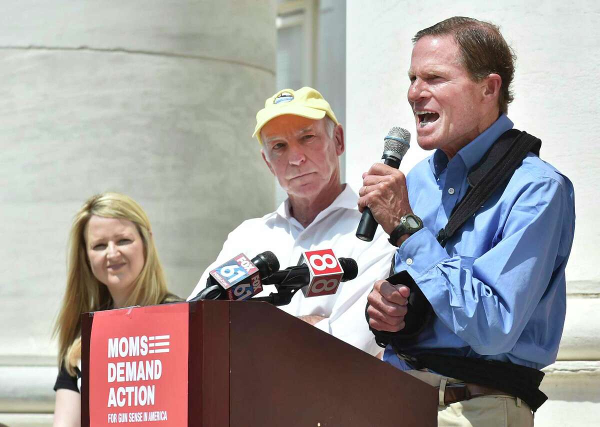 New Haven, Connecticut - Sunday, August 18, 2019: Tara Donnelly Gottlieb of Easton, an Everytown Survivor Fellow and Moms Demand Action Volunteer, left, and Congressman Joe Courtney of the 2nd Congressional District, center, listen to U.S. Senator Richard Blumenthal, D-CT,right, speak to volunteers with the Connecticut Chapters of Moms Demand Action for Gun Sense in America and Students Demand Action for Gun Sense in America activists, elected officials, and individuals affected by gun violence during a rally Sunday afternoon on the steps of the Courthouse on Elm Street and Church Street in New Haven Sunday to urge Senate Majority Leader Mitch McConnell to call the U.S. Senate back into session to take urgent action to pass universal background checks and a federal Red Flag Law.