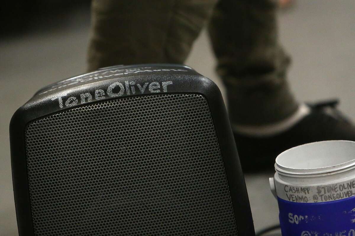 Tone Oliver’s name is seen on his speaker and donation container as he performs on a BART train for passengers on Wednesday, August 14, 2019 in Oakland, Calif.