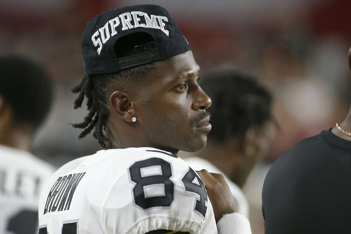 Oakland Raiders wide receiver Antonio Brown (84) puts on his helmet prior  to an NFL football ga …