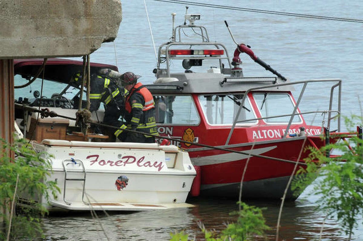 Members of the Alton Fire Department examine a boat that caught fire about 2 p.m. Saturday on the Mississippi River just north of the Ardent Mills facility. According to the department, the boat, which is owned by a Missouri man, caught fire when the inboard engine exploded. The three passengers were picked up by a passing boat and were not injured. The fire had self-extinguished by the time the fire department arrived. The boat was then towed to the Alton Marina. The department said that no fuel leaked into the river as a result of the incident.