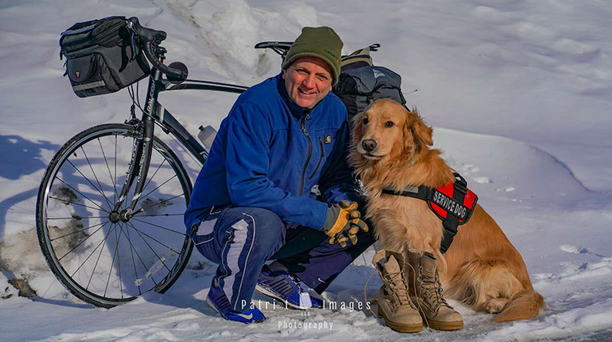 Jimmy Thomas and his service dog, Boots, appear in front of the bike Thomas rode cross country to raise funds for Woofs for Warriors. (Provided)