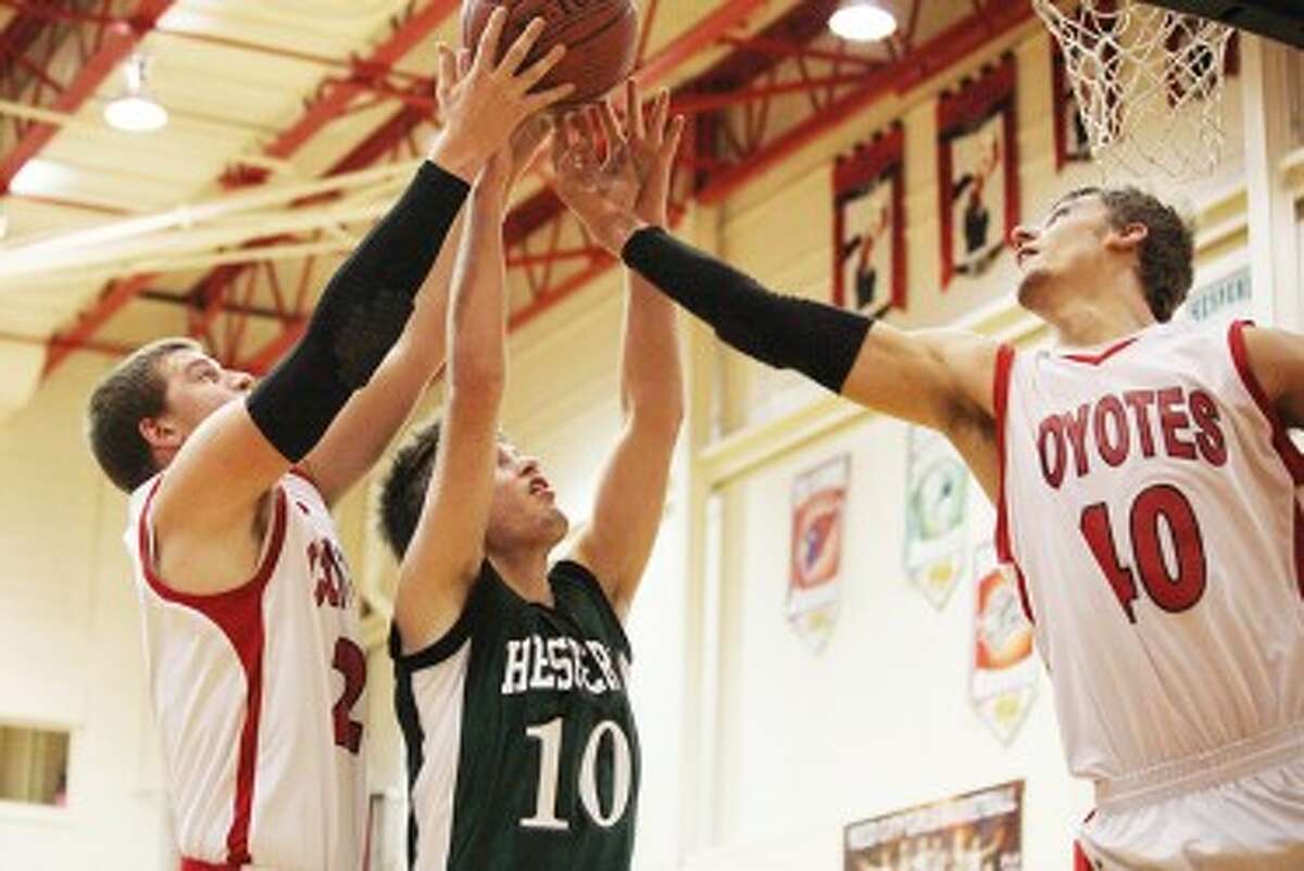 TEAM EFFORT: Reed City's Jake Vincent (right) and Ryan Willis (left) go up for a rebound on Monday against Hesperia. (Pioneer photo/Bob Allan)