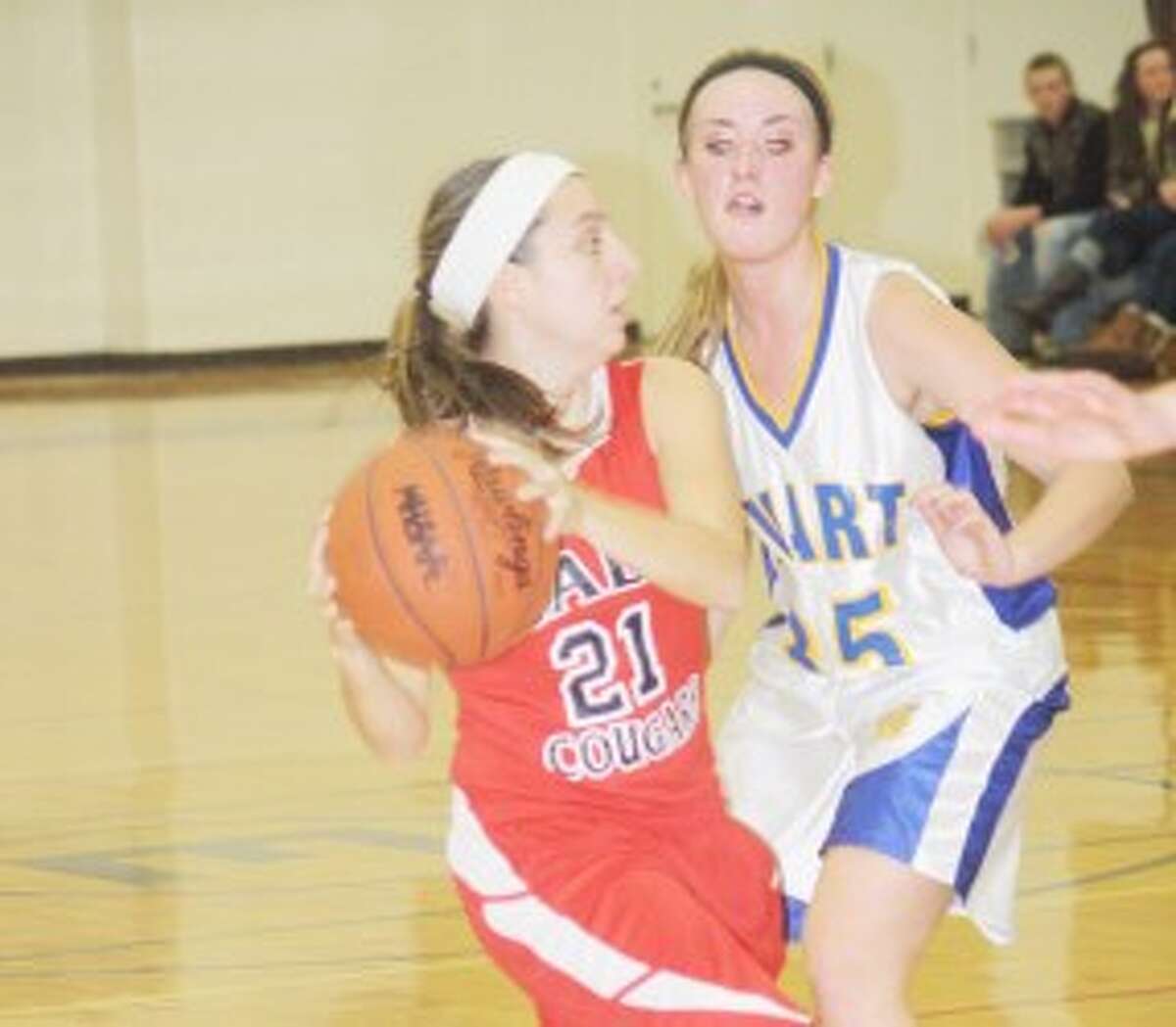LOOKING AHEAD: Crossroads' Katlin Reed (left) looks to dribble past Evart's Taylor McLachlan. (Pioneer photo/John Raffel)