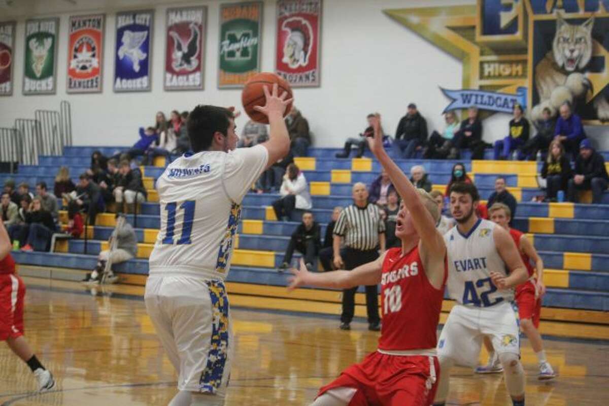 Evart's Cameron Martin (left) goes to the basket.