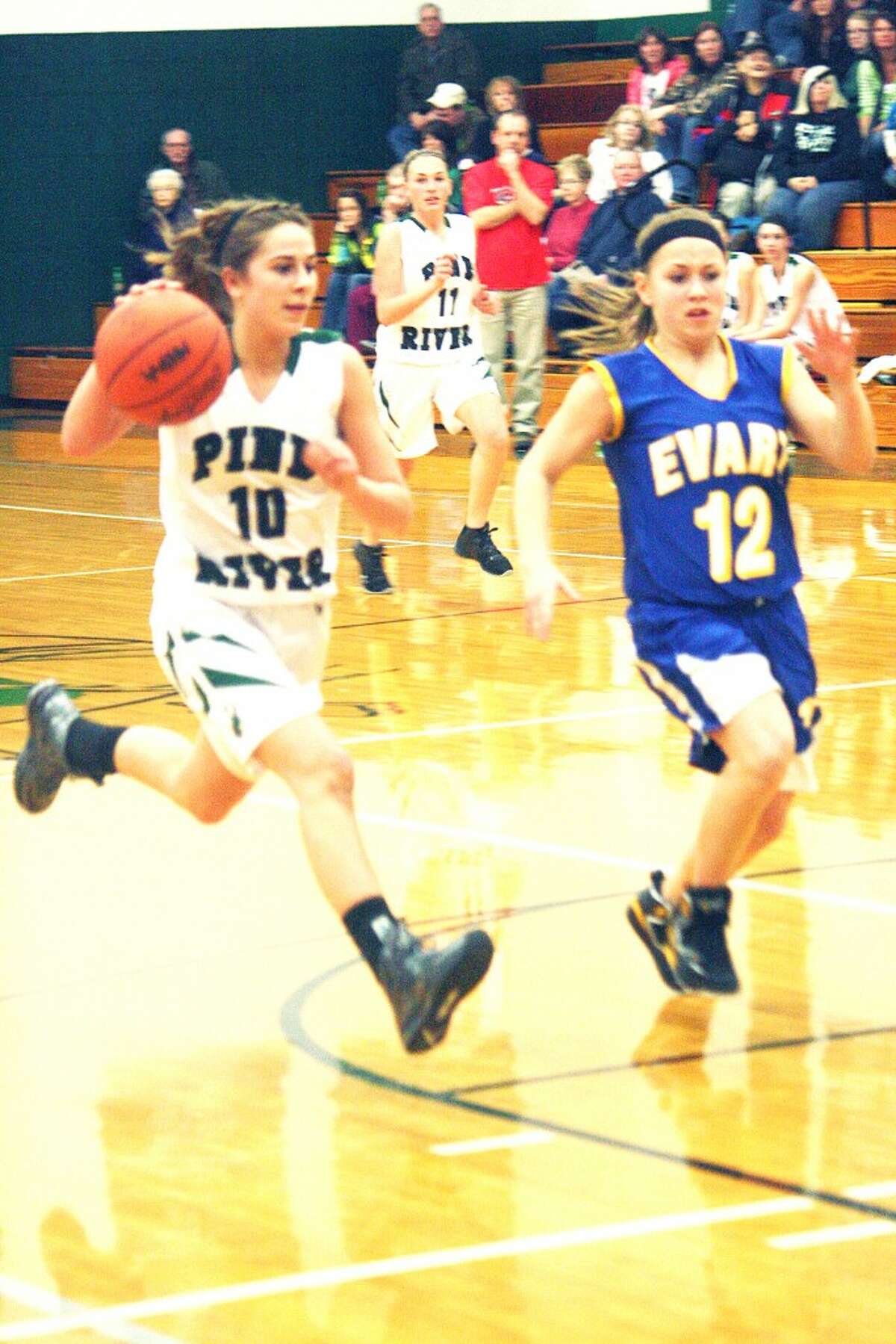 Two for Two: Kassy Nelson (10) drives past Evart's Tabby Turley (12). (Herald Review photo/John Raffel)