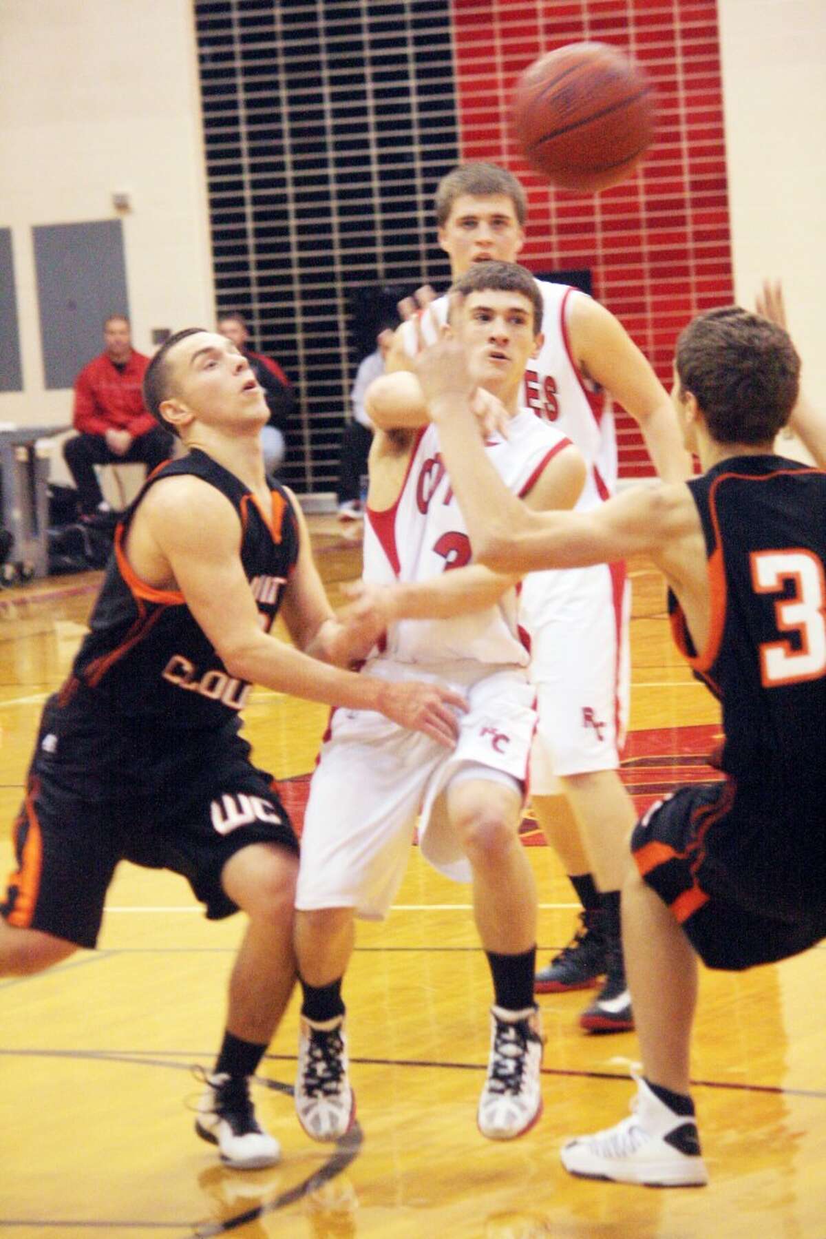 DRAWING ATTENTION: Reed City guard Joshua Saez (middle) makes a pass through traffic during Monday’s game against White Cloud. The Coyotes defeated White Cloud 73-37 to improve to 6-4 on the season. (Herald Review photo/John Raffel)