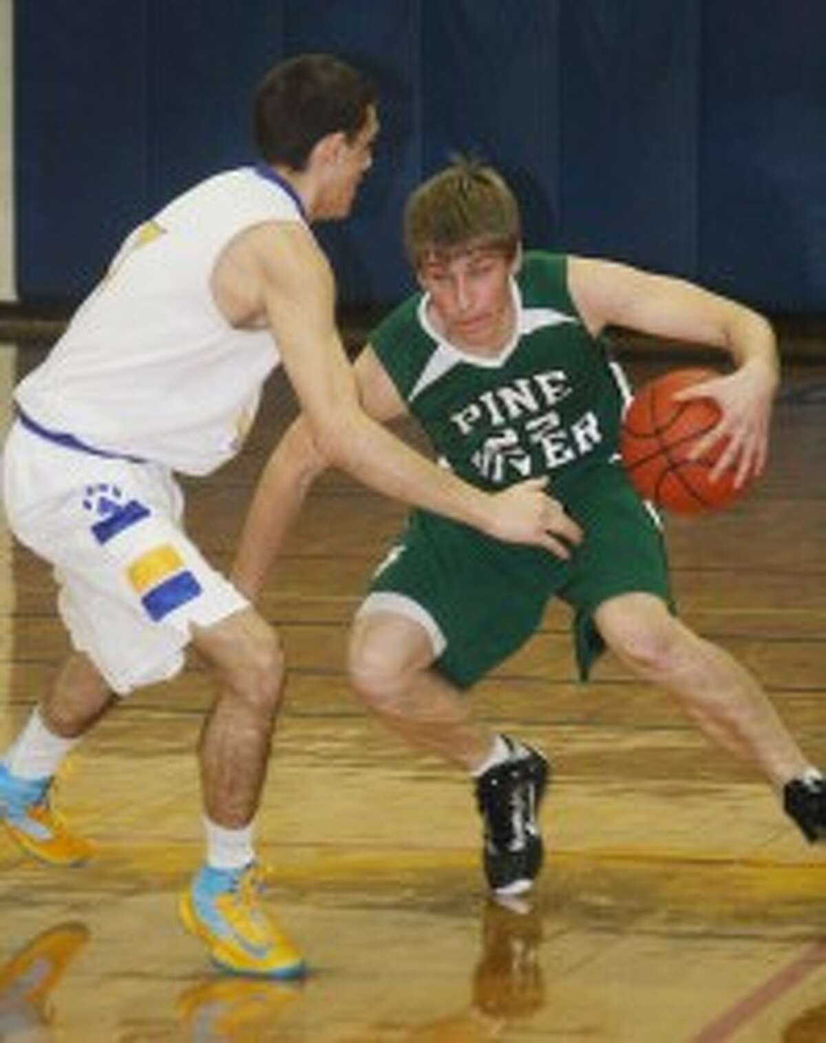 CROSSOVER: Pine River's Skyler Nelson looks to drive past an Evart defender on Thursday. (Pioneer photo/John Raffel)