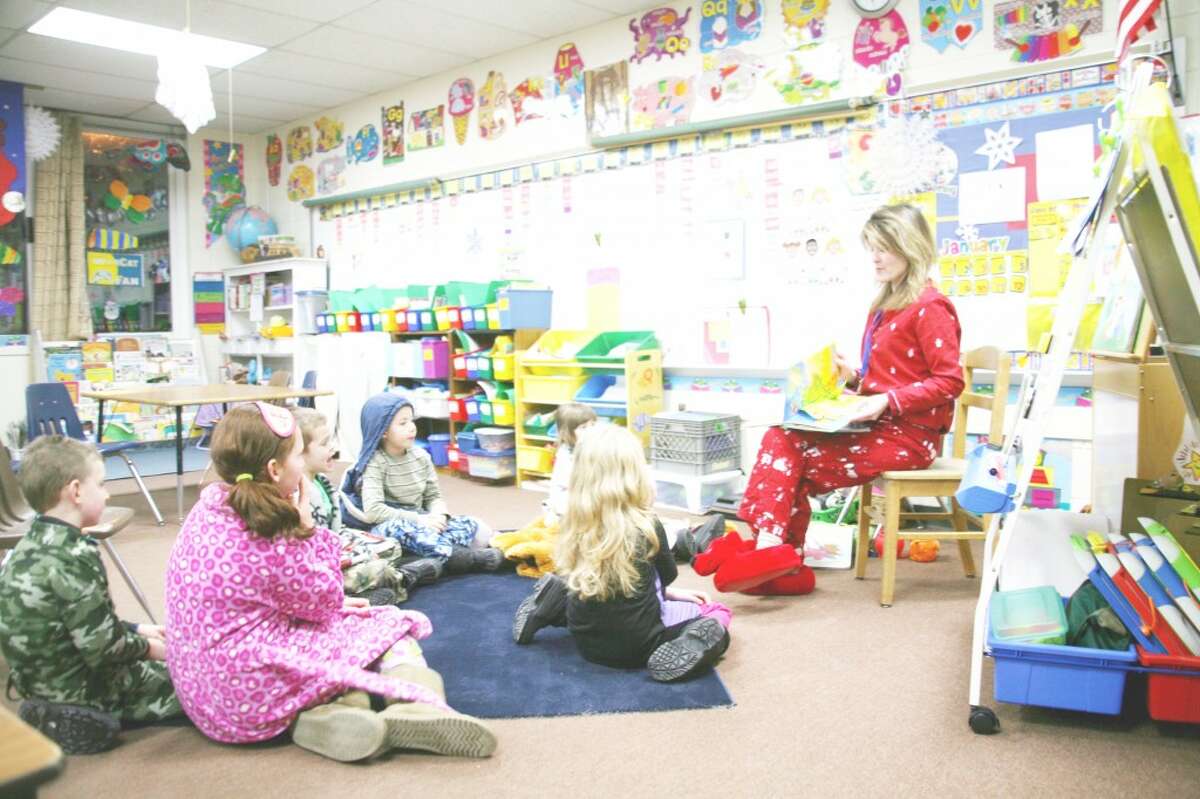 BEDTIME STORIES: First-grade teacher Sarah Ladd hosts story time in her classroom. Attendees at Thursday’s Family Night were encouraged to wear pajamas for “bedtime stories.” Several classrooms were open for story time. (Herald Review photos/Lauren Fitch)