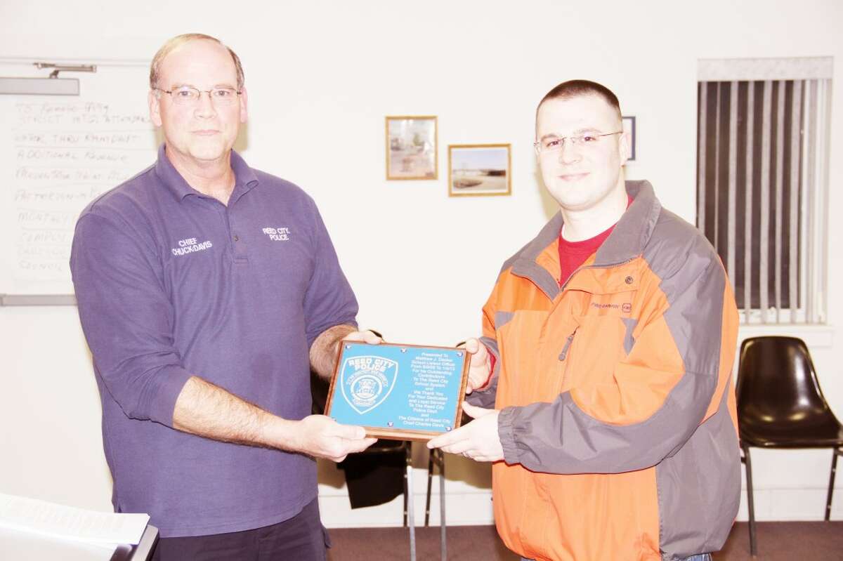 RECOGNIZED: Reed City Police Chief Chuck Davis (left) presents a plaque to Matt Decker, former Reed City Police Department schools liason officer who recently accepted a position at Ferris State University after three years with the Reed City Police Department. (Herald Review photo/Sarah Neubecker)