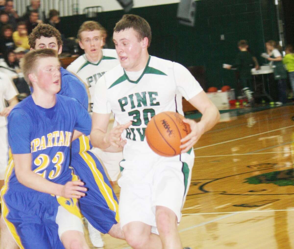 IN THE LANE: Pine River's Devin Ruppert (right) drives to the basket against Mason County Central on Monday. (Herald Review photo/John Raffel)