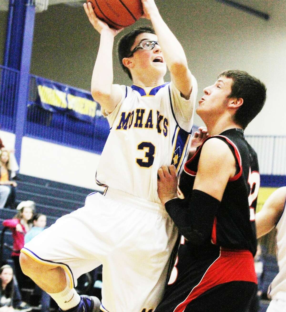 ROUGH GAME: Morley Stanwood’s Tim Cairndruff (left) drives to the basket while being defended by Kyle Wright of Reed City. (Herald Review photo/Bob Allan)