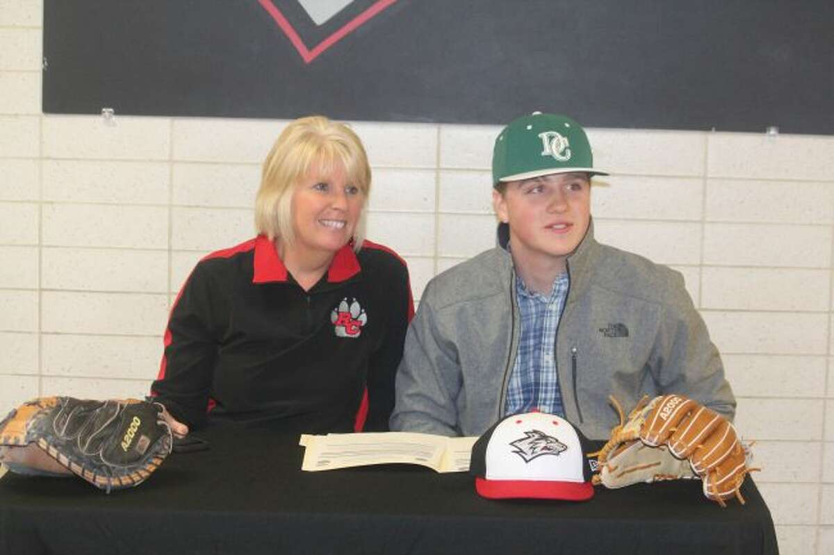 Reed City athletic director Kris Griffith and Jeffery Phenix are all smiles at his signing ceremony.