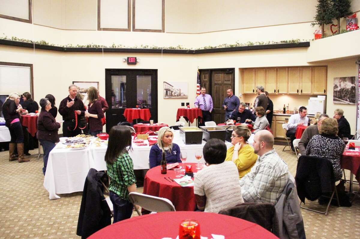 PARTY TIME: Community members gathered at the Reed City Depot Friday for the Stop in the Name of Love party and silent auction. All proceeds raised at the event will benefit the Reed City Area Chamber of Commerce.