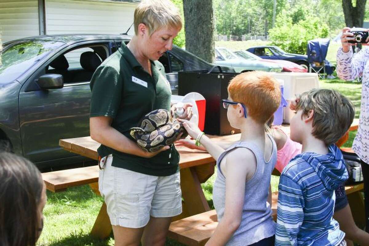 SLITHERY SNAKE: Zoo Instructor Tara Lafferty from John Ball Zoo holds a python while children line up to pet the snake after her presentation.