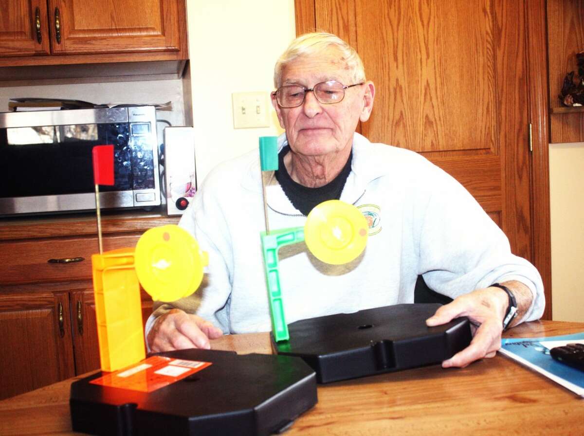 HOME “MADE”: Don Akers of Osceola County assembles two sets of his Fish Brothers Tackle Co. tip-ups at his Tustin home. (Herald Review photo/John Raffel)