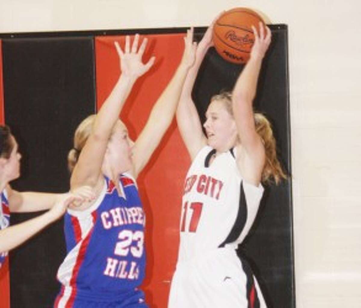 FINDING A TEAMMATE: Reed City's Natalie Westhoff (11) tries to pass the ball while being defended by Teagan Denslow of Chippewa Hills. (Pioneer photo/John Raffel)