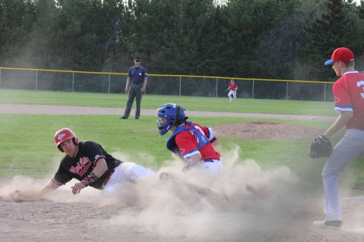 Stephen Showan slides safely into home plate against Chippewa Hills.