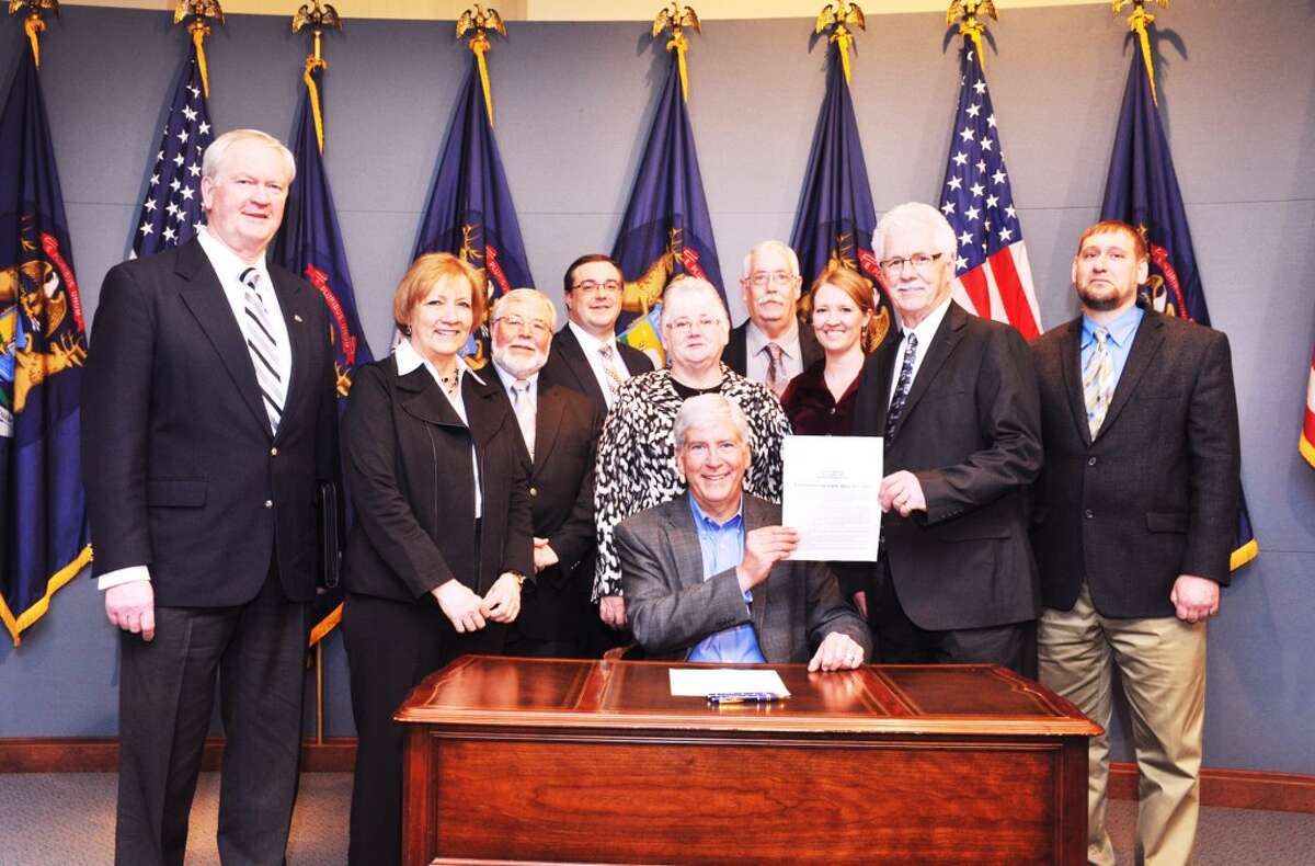 SIGNED LEGISLATION: Gov. Rick Snyder (center) signed a bill that will increase payments in lieu of taxes (PILT) to local governments for state-owned land within their boundaries. The legislation was enacted last month. (Courtesy photo)