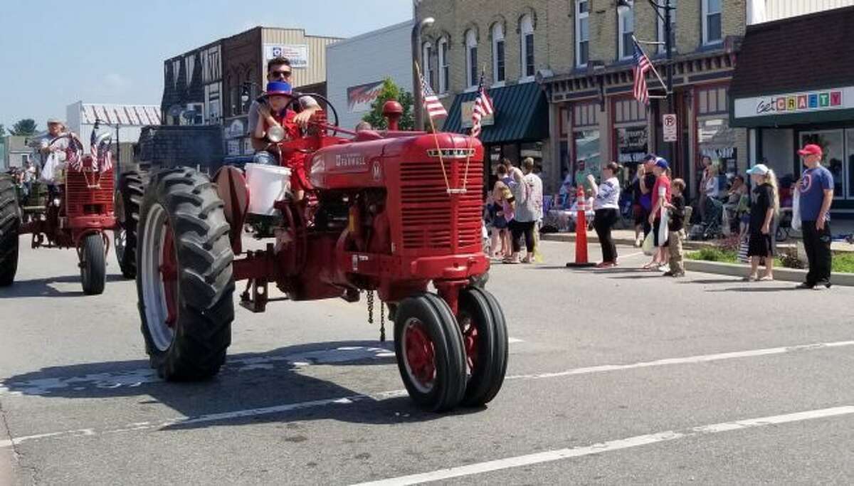 As community members passed by on tractors, drivers and passengers tossed candy and beads to the many children lining Main Street.