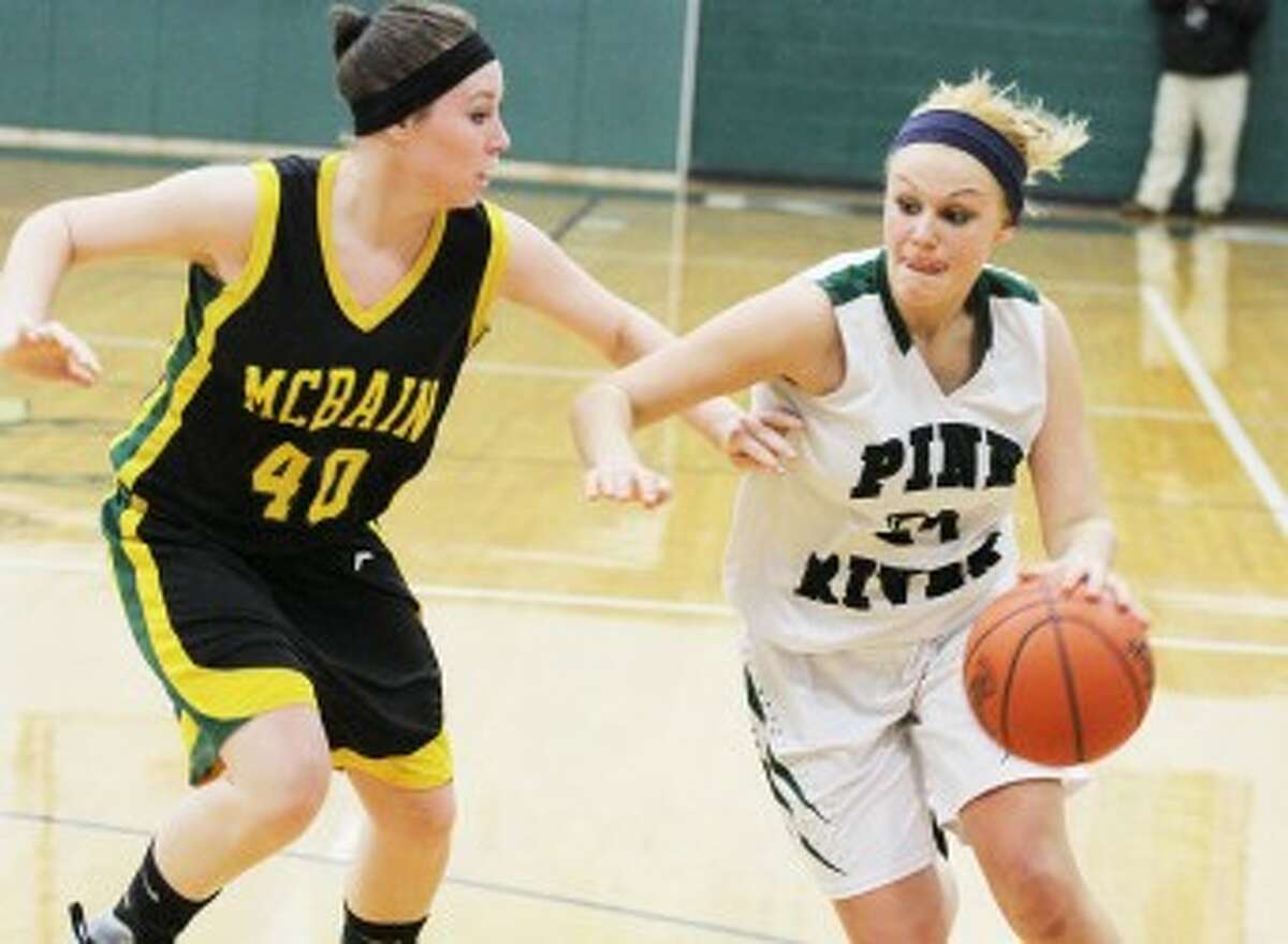DRIVING: Pine River's Haley Raymond (right) drives to the basket against McBain during Friday's district final. The Bucks won the game 54-32 to claim their second district title in three years. (Pioneer photo/Martin Slagter)
