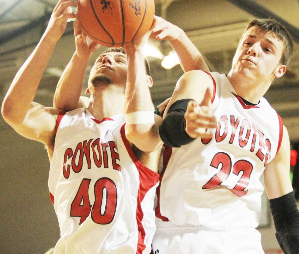 UP FOR GRABS: Reed City’s Jake Vincent (left) and Kyle Wright battle for a rebound against Clare during the the Class B district semifinal. (Herald Review photo/Bob Allan)