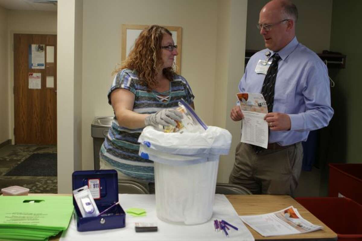 During the Tuesday, Aug. 28, medication and needle take-back event in Evart, (from left) Shay Tullar, Ten16 Recovery Network prevention coordinator, and Scott Lombard, community outreach manager for Spectrum Health Big Rapids and Reed City hospitals, discuss upcoming take-back dates set through the rest of this year at different locations in Mecosta and Osceola counties. (Herald Review photos/Meghan Gunther-Haas)