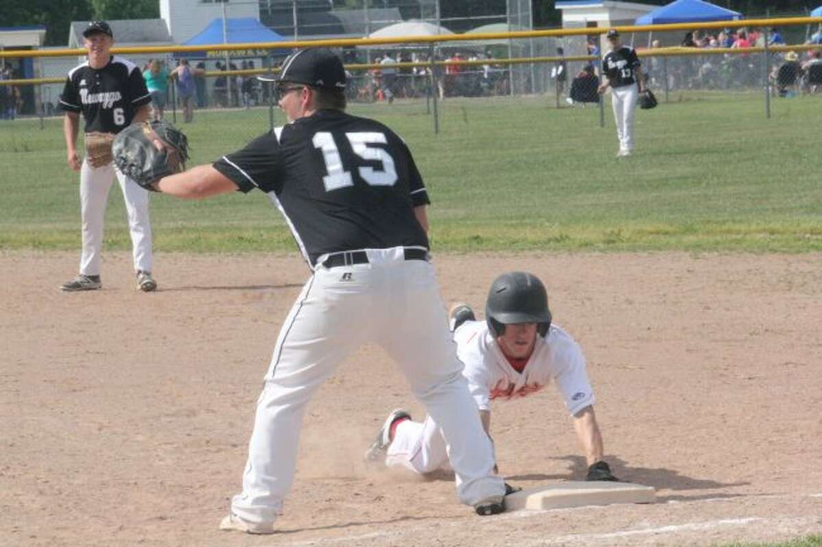 HE'S SAFE: Reed City's Hunter Morrison slides back into first base.