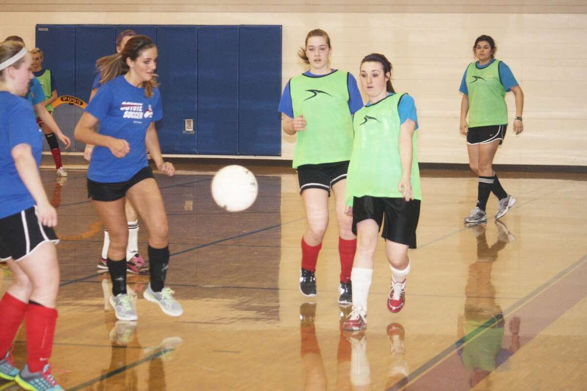 WORKING OUT THE WEATHER: Reed City girls keep an eye on the ball during an indoor soccer practice last week. (Herald Review photo/John Raffel)