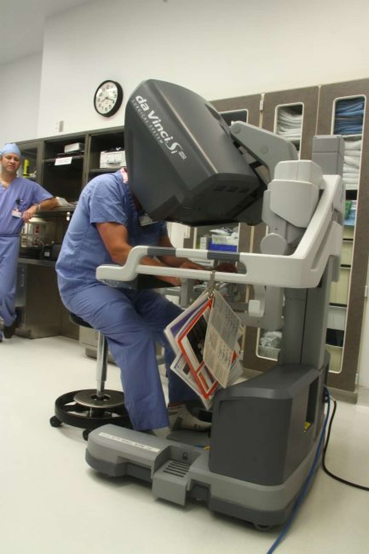 Dr. Mark Haan sits at the console of the da Vinci robotic-assisted surgery system. The console is where the surgeon makes the movements which will be carried out by the machine’s mechanical arms.
