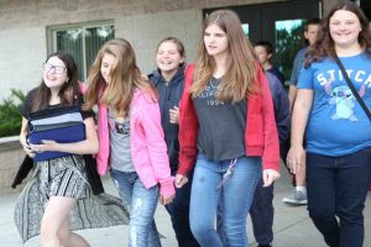 Evart middle-schoolers leave the high school building, where they were dropped off, and board buses headed to SpringHill Camps. Middle school students spent Thursday, Aug. 24, through Monday, Aug. 28, at the camp while work was completed at their building.