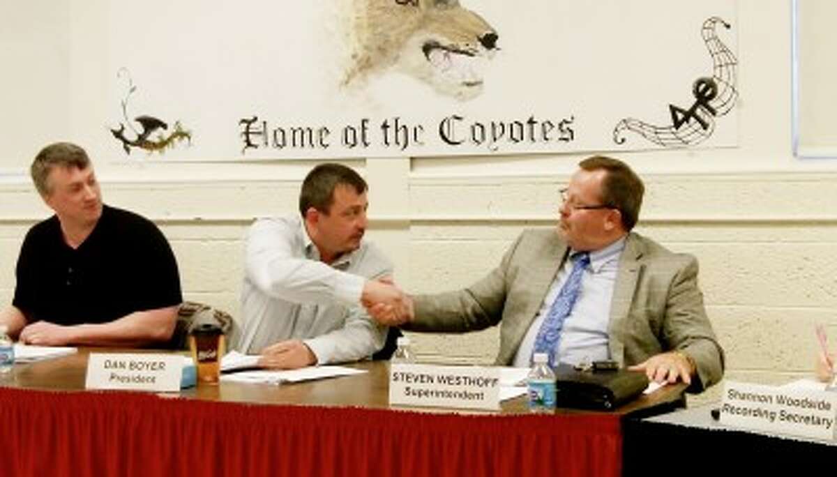 PARTING AGREEMENT: RCAPS board president Dan Boyer (center) shakes hands with Superintendent Steve Westhoff after the board approved a $65,133 retirement incentive for him, with the potential for another payment of the same amount. (Pioneer file photo)