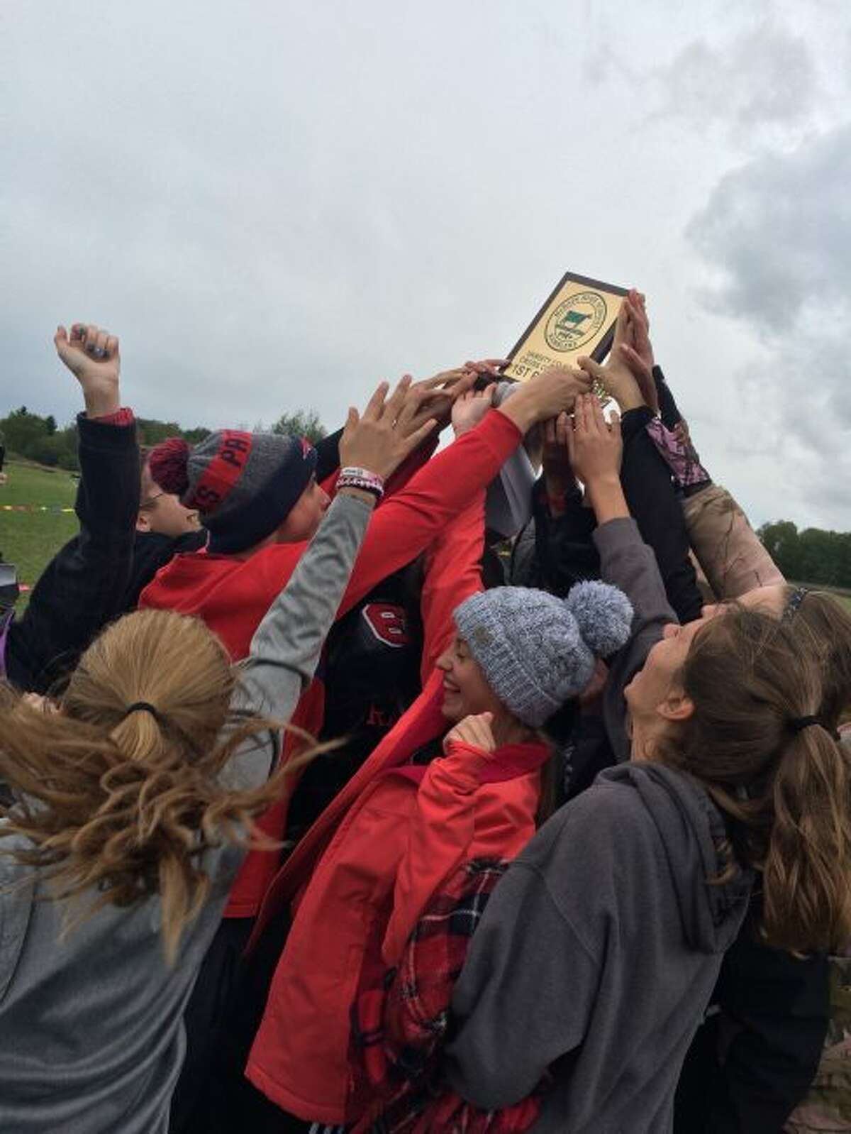 Reed City cross country runners celebrate trophy at McBain