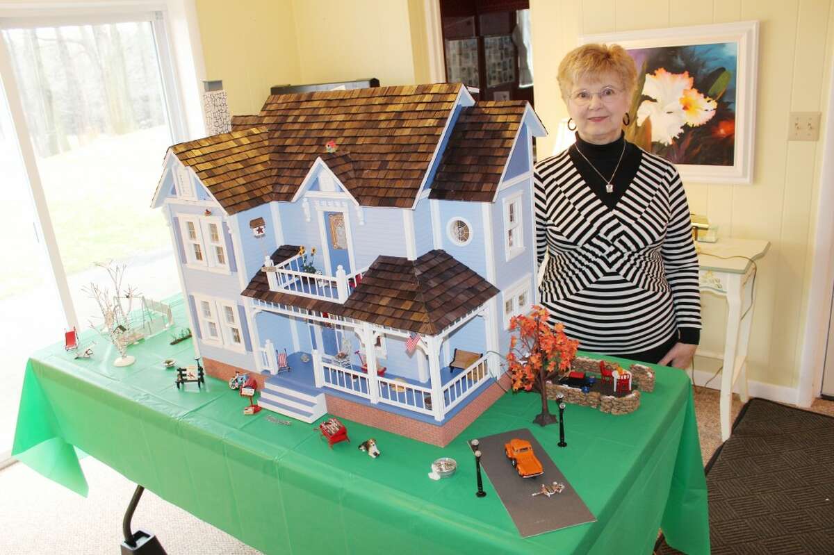 Dollhouse: Local crafter and painter Sandy Sikkila of Reed City poses next to the dollhouse she recently finished for Stacy Gilland after four years of detailed work. Gilland said she loves the house and is thankful for Sikkila’s dedication. (Herald photo/Karin Armbruster)