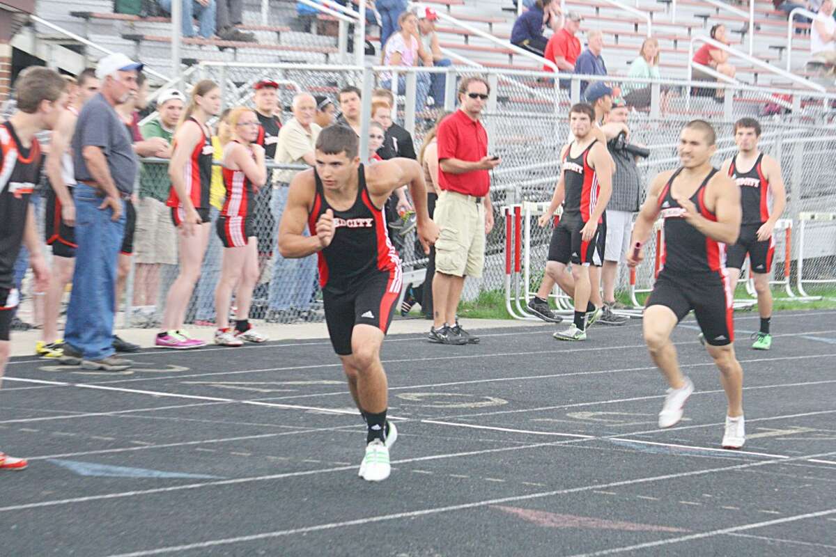 Victory: Eric Voelker (front) gets set to take the baton in the 1,600-relay during Reed City track action last week. (Herald Review/John Raffel)