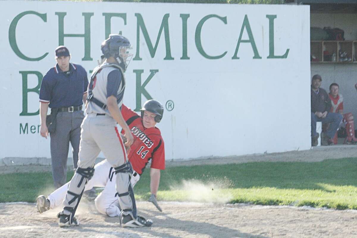 SLIDE: Ray Phenix (14) of Reed City slides into home plate. (Herald Review photo/John Raffel)