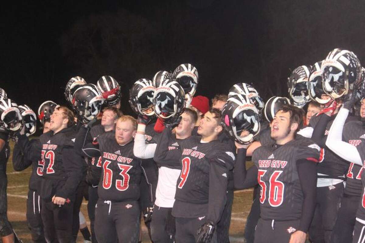 Reed City players sign fight song after taking regional title.