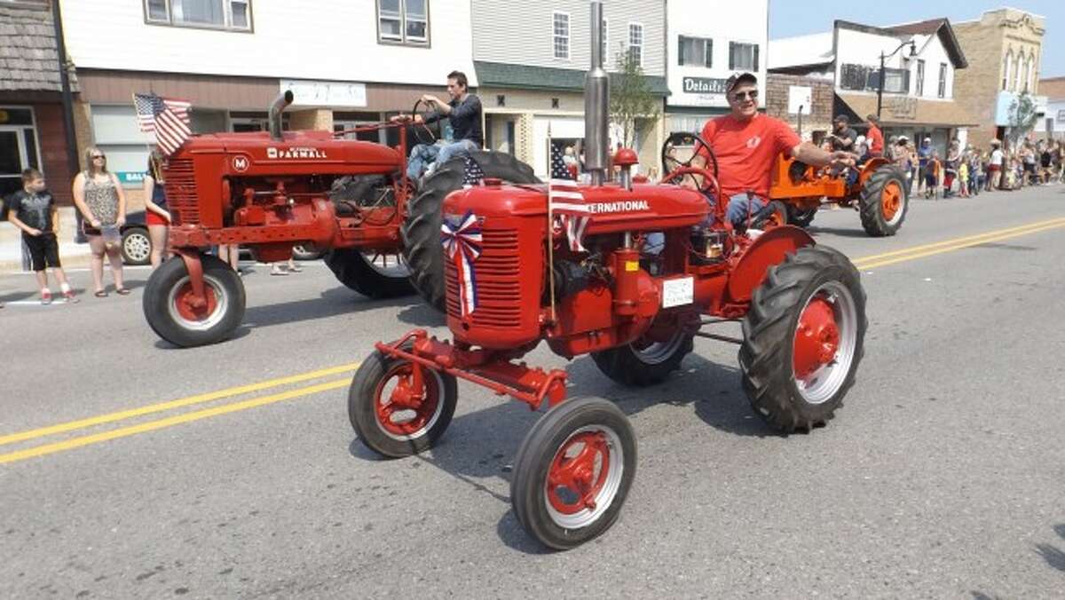 PARADE: A variety of tractors and classic cars rolled down Main Street in Evart as hundreds lined the sidewalks to watch the annual parade and collect candy thrown from floats and walkers.