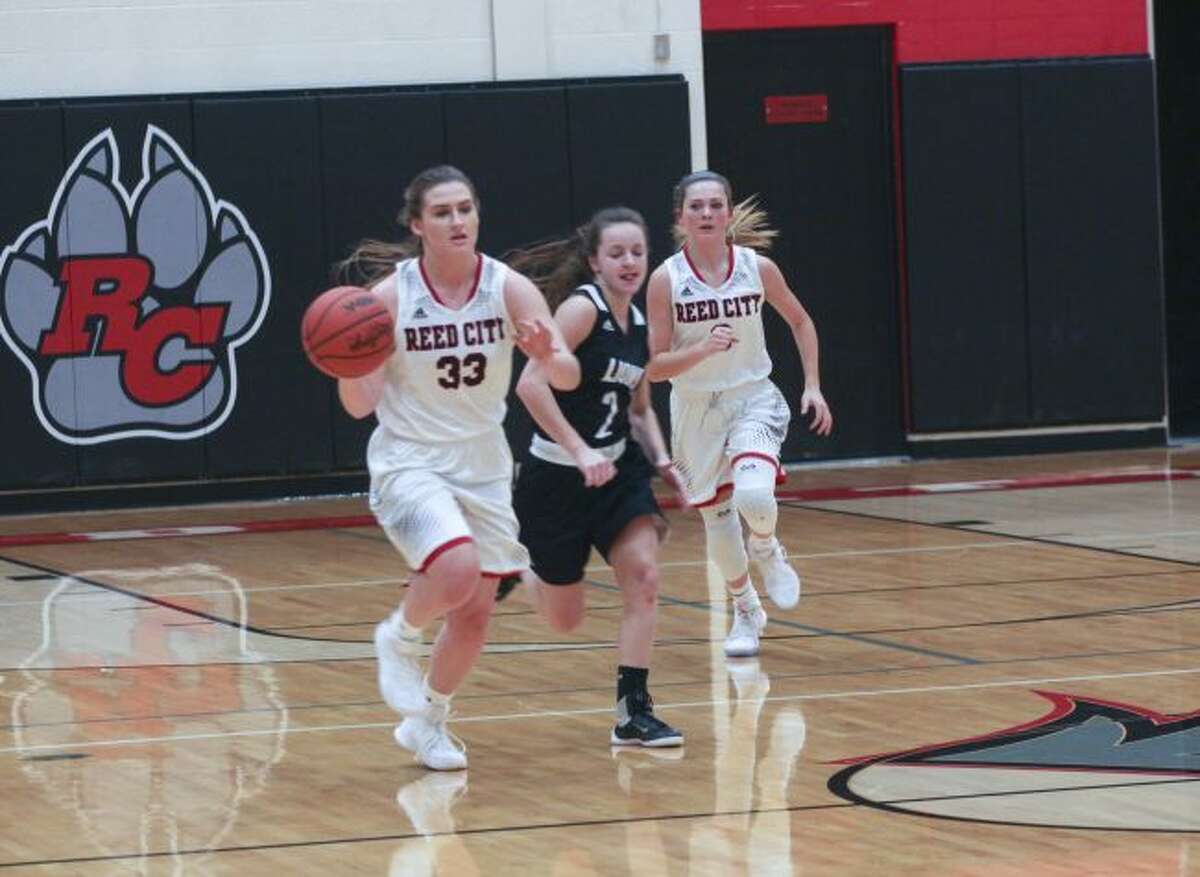 Emily Libey (33) heads up the court for Reed City.